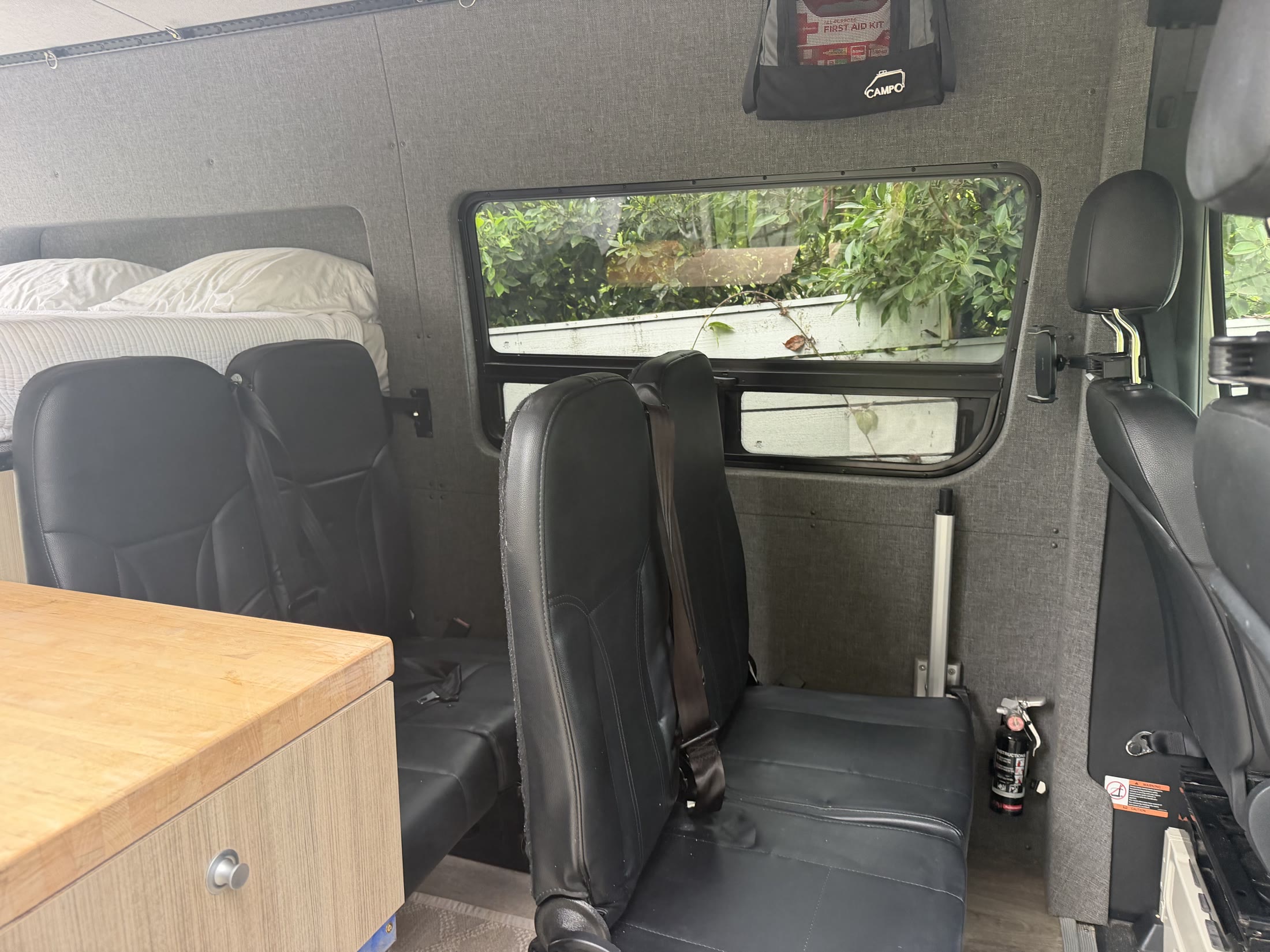 Rear passenger seats folded down in their sitting position inside the camper cabin